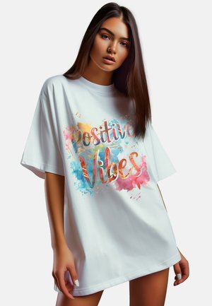 Overmaatse witte t-shirt gemaakt van katoen, met een kleurrijk aquarelontwerp en de tekst "Positive Vibes" in goud en levendige spetters.
