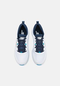 White golf shoes with navy accents, textured mesh upper, navy laces, and light blue eyelets, featuring a cushioned interior and logo detail.