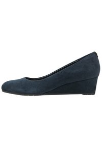 Scarpa con zeppa in suede blu navy, dotata di punta arrotondata e una leggera curvatura nella tomaia, caratterizzata da una finitura testurizzata e una suola a profilo basso.