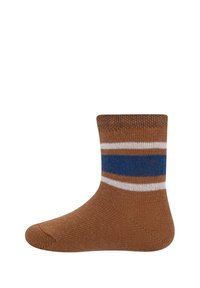 Brune bomullssokk med ribbet mansjett, med hvite og blå striper rundt ankelen. Rund tå og myk tekstur.