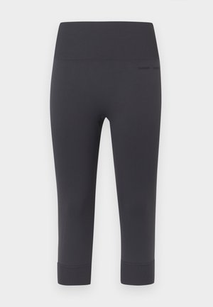 Leggings negros hasta tres cuartos de largo con una textura suave y elástica y una cinturilla ancha. Presentan una marca minimalista en el lateral.
