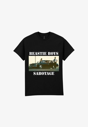 Zwarte katoenen t-shirt met een vintage auto graphic waarop drie individuen te zien zijn, voorzien van de tekst "BEASTIE BOYS" en "SABOTAGE" in vetgedrukte witte letters.