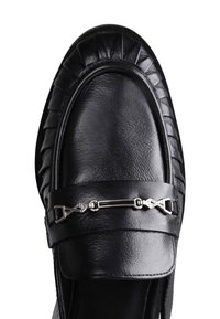 Mocasines de cuero negro con detalles plisados, un acabado suave y un acento de metal plateado en la parte superior. Forma y textura clásicas.