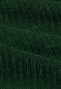 Tejido de pana verde oscuro con textura de estrías verticales, superficie suave y peluda, y patrón uniforme en todo su recorrido.