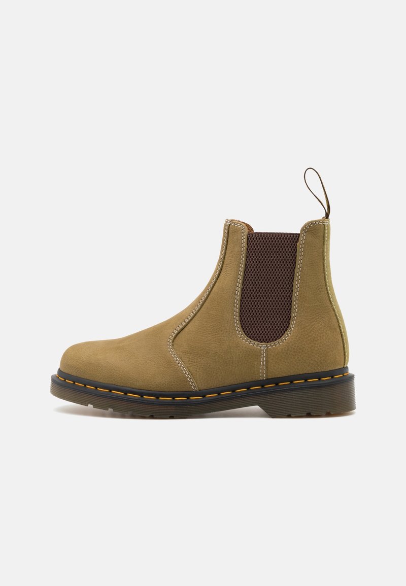 Bottine Chelsea en daim couleur fauve avec un panneau latéral élastique, semelle noire avec coutures jaunes, et un tirette au talon, vue de profil gauche.