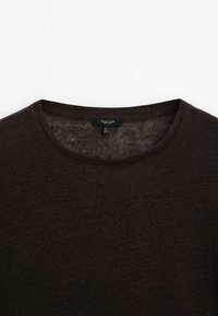 Maglione marrone scuro con scollatura rotonda, realizzato in un materiale morbido e testurizzato. Etichetta visibile all'interno dell'area del collo.