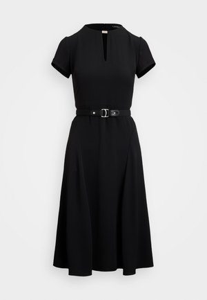 Robe noire à manches courtes, décolleté rond, ouverture en forme de trou de serrure à l'avant et ceinture ajustée à la taille. Jupe fluide.