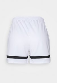 Shorts de sport blancs en matériau léger, avec une bande noire horizontale près de l'ourlet et une taille élastique.
