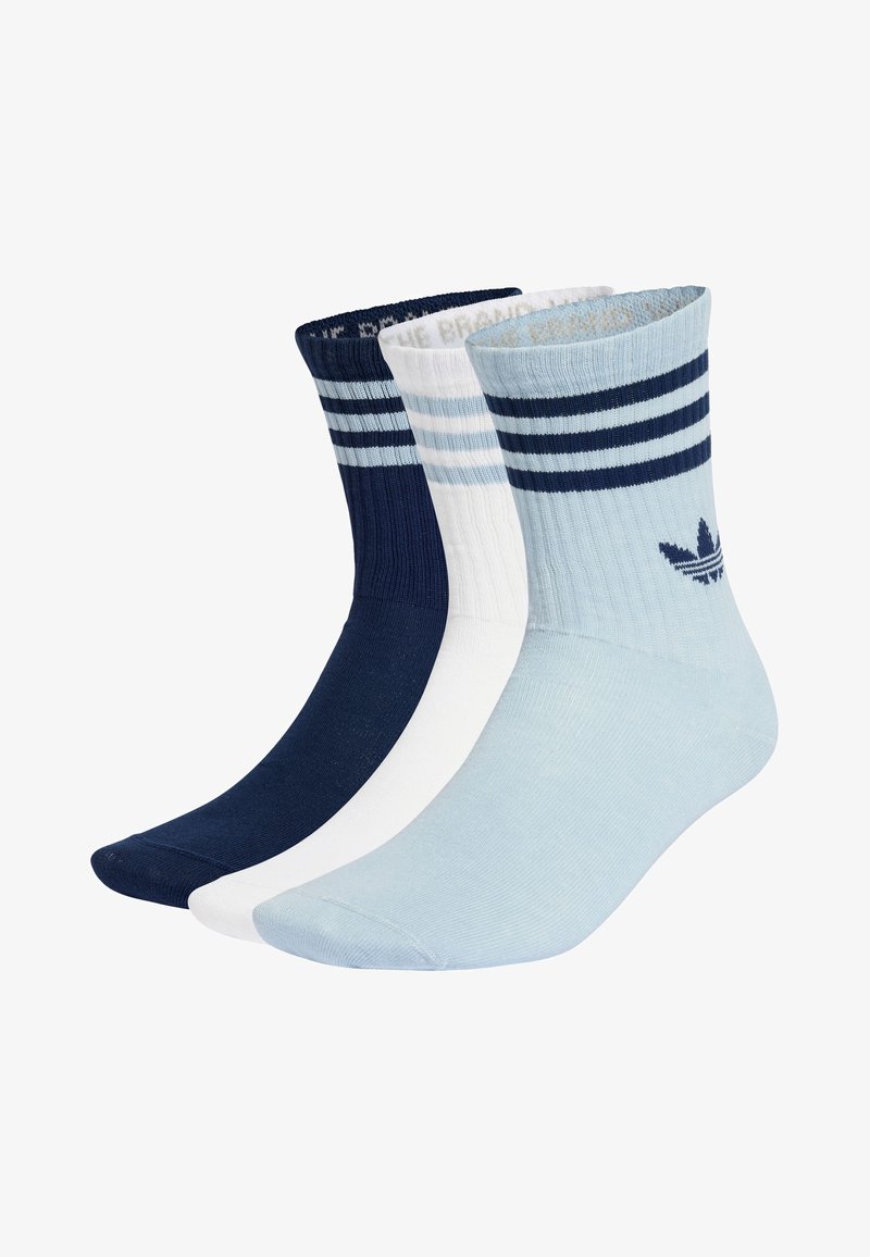 Drei Paar Crew-Socken: dunkelblau, weiß und hellblau. Jede Socke hat breite horizontale Streifen oben und ein Logo auf der hellblauen Socke.