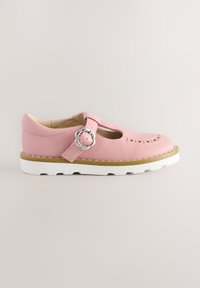 Chaussure en cuir rose à bout rond, motifs découpés, bride à boucle et semelle en caoutchouc blanche avec accents texturés. Détail élégant de boucle florale.