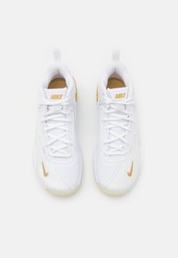 Hvite Nike-sneakers med en strukturert design. Har gullfargede detaljer på merket og sidedesignen Swoosh. Snøring med en trekkflik på hælen.