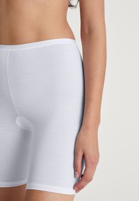 Witte katoenen shorts met een elastische tailleband, voorzien van een naadloos ontwerp en een klein rond uitsnede aan de voorkant.