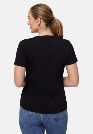 Černé tričko s krátkým rukávem, měkká tkanina, běžný střih, kulatý výstřih, jednoduchý design. Nosené s modrými džínami s zadními kapsami.