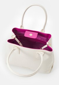 Vit texturerad handväska med två handtag, med en livfull rosa insida och en tryckknappslåsning. Inkluderar en innerficka med dragkedja.