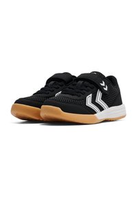 Chaussures de sport noires avec une tige en mesh, des accents blancs et une sangle Velcro. Elles présentent une semelle rembourrée avec un fond en caoutchouc brun.