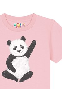 T-shirt rose à manches courtes avec un panda en dessin animé ayant des oreilles et des membres noirs, souriant et faisant signe, sur un tissu lisse.