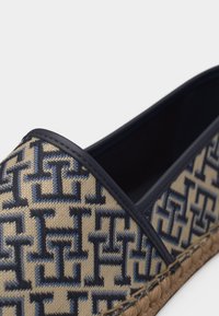 Εσπαντρίγια με μπεζ ύφασμα καλυμμένο με σκούρο μπλε διαπλεκόμενο γεωμετρικό σχέδιο και πλεκτή σόλα από τζούτ.