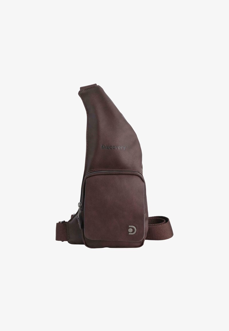 Brown leather sling bag with a slightly tapered design, featuring a front zip pocket, adjustable strap, and embossed logo. Soft texture.