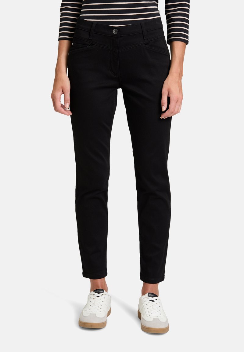 Svarta slim-fit jeans tillverkade av stretchtyg, med klassisk knapplåsning och dragkedja, framfickor, och minimala sömnadsdetaljer.