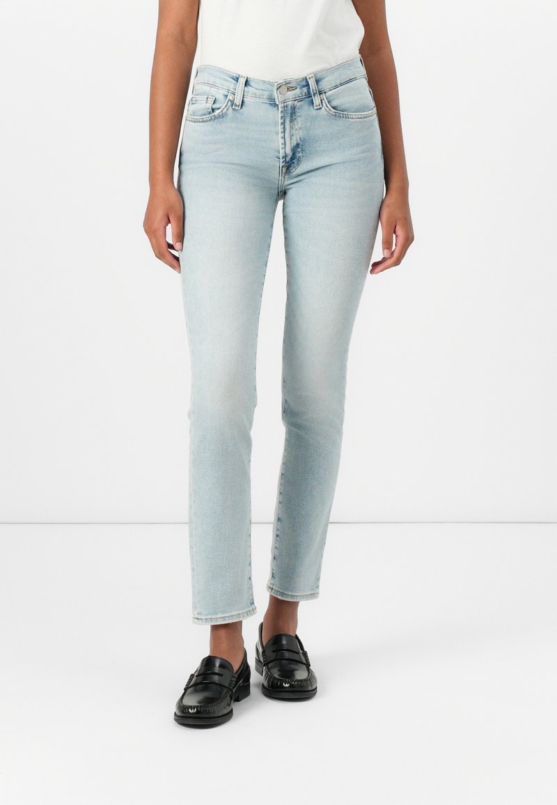 Lichtblauwe jeans met rechte pijpen van denim met een vervaagde was, met vijf zakken en een knoopsluiting. Draag met zwarte instappers.