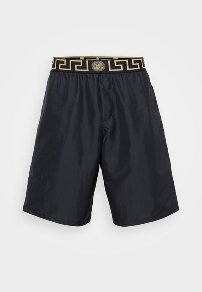 Melni peldbikses, kas izgatavotas no gludas auduma, ar zelta rakstu elastīgu jostu ar logo un sānu kabatām funkcionalitātei.