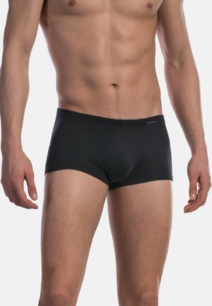 Männlicher Torso und obere Beine, bekleidet mit einfachen schwarzen Boxershorts vor einem schlichten hellen Hintergrund.