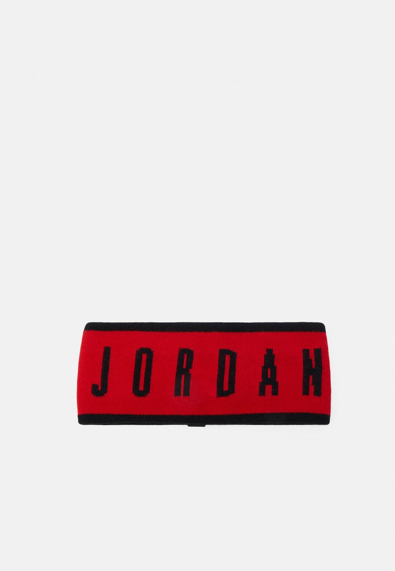 Un bandeau en tissu rouge et noir présentant le mot "JORDAN" en lettres noires en gras. Texture tricotée, forme rectangulaire, conçu pour le sport ou le port décontracté.