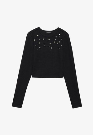 Pull cropped noir à manches longues avec un col arrondi, orné de détails en perles blanches éparpillées sur le devant.