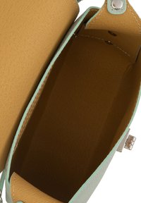 Rakenteellinen käsilaukku, jossa on teksturoitu mintunvihreä ulkopinta ja sileä sinapinkeltainen sisustus. Varustettu metallisella lukolla ja näkyvillä ompelu yksityiskohdilla.