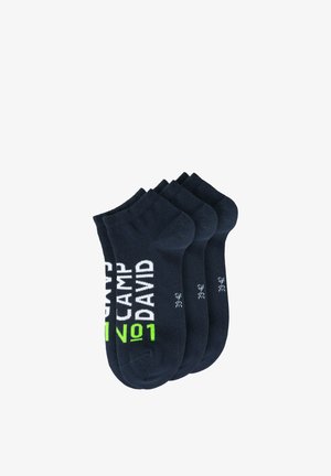 Four pairs of black ankle socks stacked, featuring white and green "CAMP DAVID No1" text and size 39-42 on each sock.