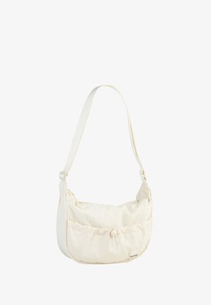 Textured cream bag with a curved shape, adjustable strap, drawstring closure, and a subtle logo detail on the front.