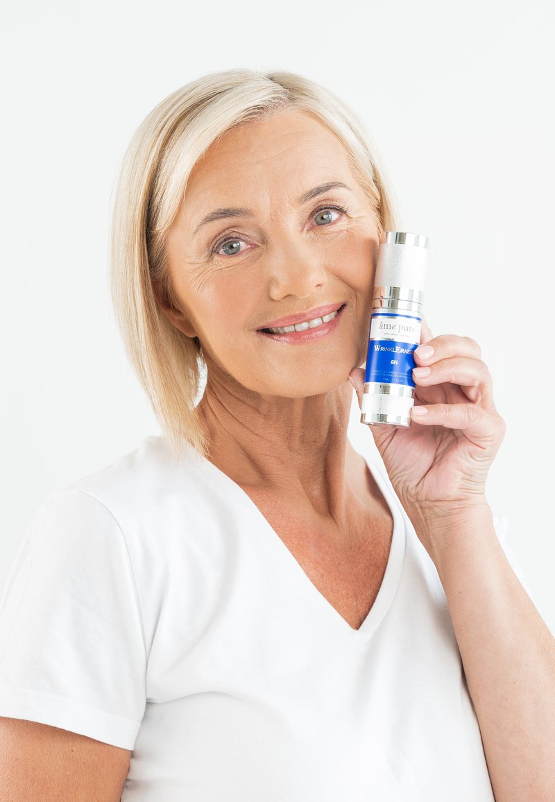 Ame Pure Wrinkle Breaker Gel in einer silbernen und blauen Flasche, gehalten von einer Frau in einem weißen Shirt, mit glatter, eleganter Textur und minimalistischem Design.