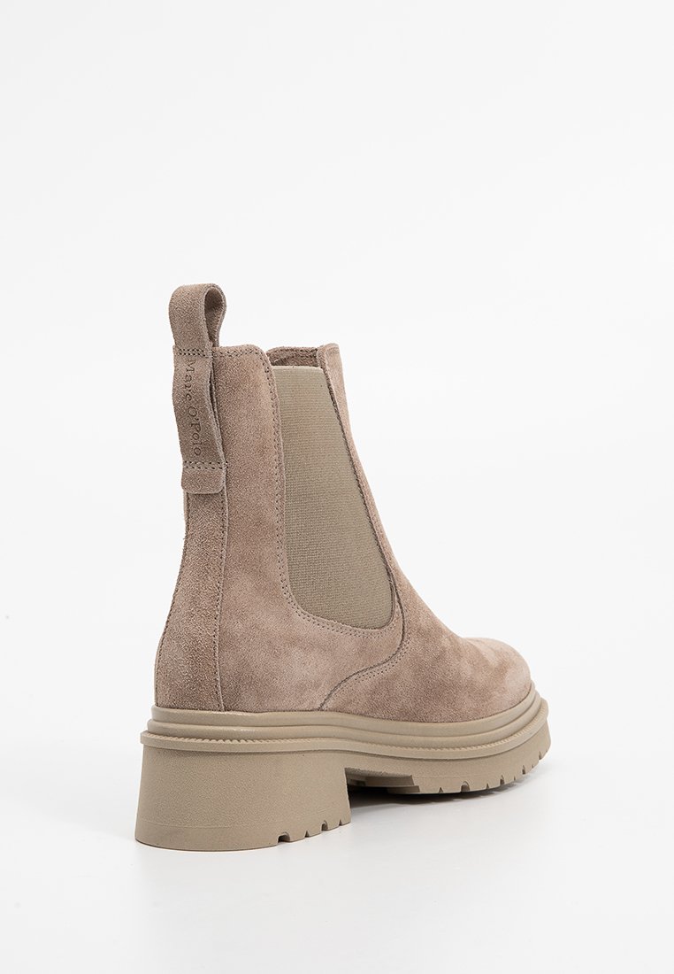 Brązowe zamszowe botki za kostkę z elastycznymi wkładkami po bokach, pętlą do zakładania oraz grubą beżową gumową podeszwą z bieżnikiem.