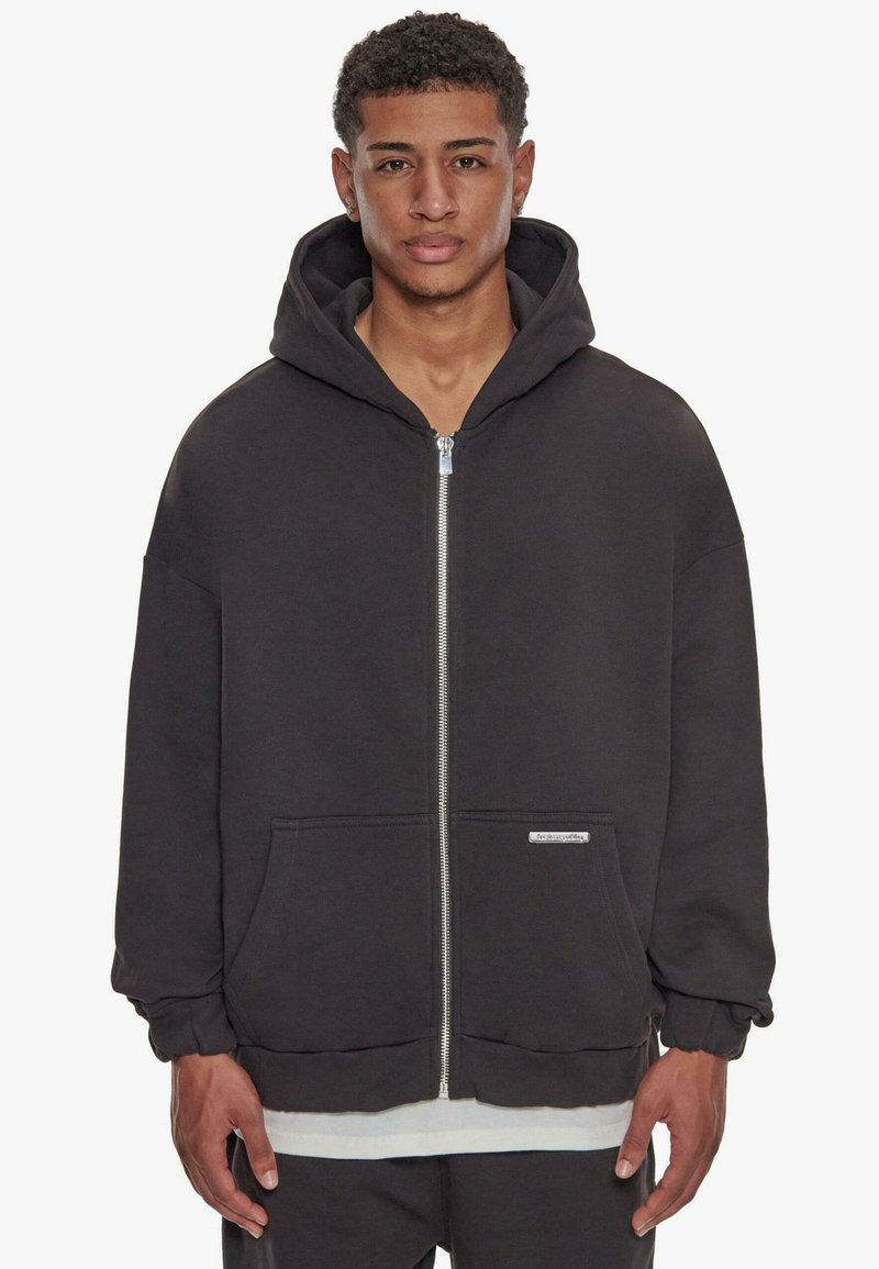 Sort zip-hoodie med en stor hætte, frontlommer, ribbede manchetter og et tekstureret stof. Har et lille logo på den nederste venstre side.