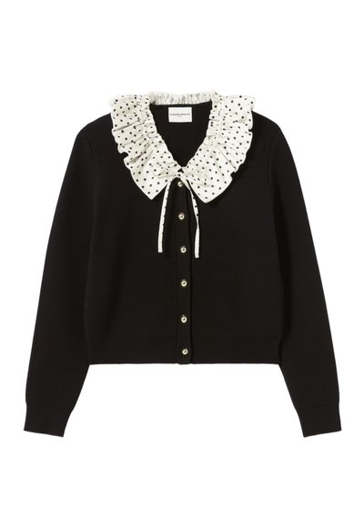 Cárdigan negro con un cuello rizado de lunares blancos, frente abotonado y puños acanalados. Textura suave, diseño ajustado, aspecto clásico.