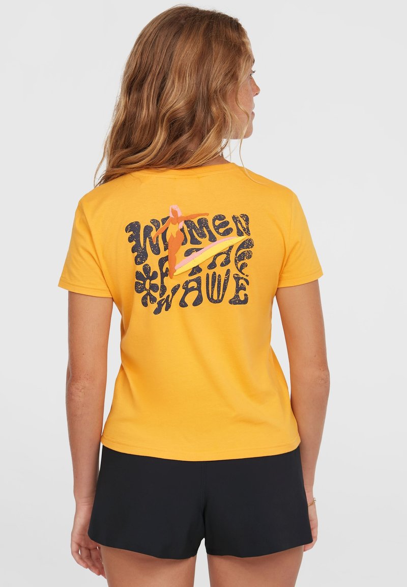Geel katoenen T-shirt met een gedurfde grafische print op de achterkant, met de tekst "Vrouwen van de Golf" en een surfillustratie.