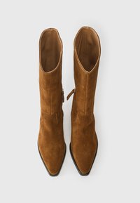 Καφέ σουέτ μπότες μέχρι τον αστράγαλο με μυτερή μύτη και πλαϊνό φερμουάρ. Ο σχεδιασμός διαθέτει δομημένο σχήμα και λείο εσωτερικό επένδυση.