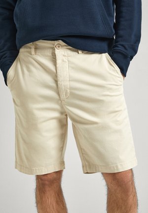 Beige katoenen shorts met een ritssluiting en knoopsluiting, voorzien van zijzakken en een rechte pasvorm, eindigend net boven de knie.