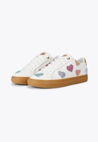 Sneaker bianche con motivi a cuore multicolori, dettagli testurizzati e una suola in gomma marrone. Presentano lacci piatti e occhielli dorati.