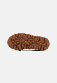 Suola di scarpa in gomma con un motivo di battistrada esagonale e lineare. Materiale grigio scuro con accenti arancio-marroni, caratterizzata da un punta arrotondata e un bordo bianco.