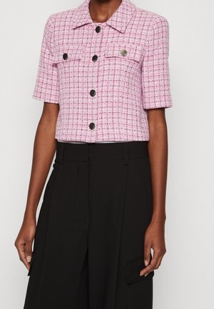 Różowa, przerobiona, krótka marynarka z tweedu z czarnymi guzikami, noszona z czarnymi, szerokimi spodniami z wysokim stanem i kieszeniami cargo.