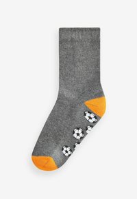 Grau Baumwollsocke mit orangefarbener Ferse und Spitze. Verziert mit einem schwarz-weißen Fußballmuster an der Seite. Glatte Textur, mittellange Höhe.
