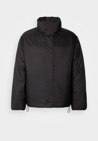 Veste matelassée noire avec col haut, manches longues et cordons ajustables à l'ourlet, vue de face sur un fond uni.