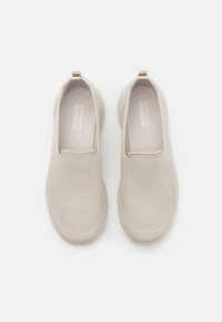 Mocassins beiges en matériau en maille respirante, dotés d'un bout arrondi lisse, d'une semelle intérieure rembourrée, et d'un design minimaliste avec un logo subtil.