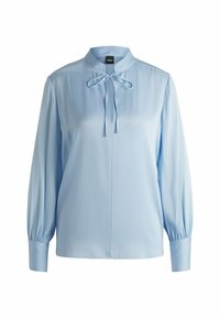 Blusa azzurra a maniche lunghe con colletto rialzato, dettaglio con nodo al collo, tessuto morbido e maniche arricciate ai polsini.