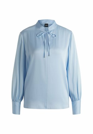 Jasnoniebieska bluzka z długim rękawem, z kołnierzykiem stójkowym, zawiązywanym detalem przy szyi, gładkim materiałem i pełnymi rękawami przy mankietach.