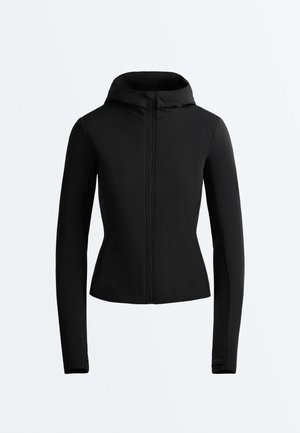 Geacă neagră mulată, cu mâneci lungi, fermoar în față și glugă fixată, prezentată pe un fundal simplu, deschis la culoare.