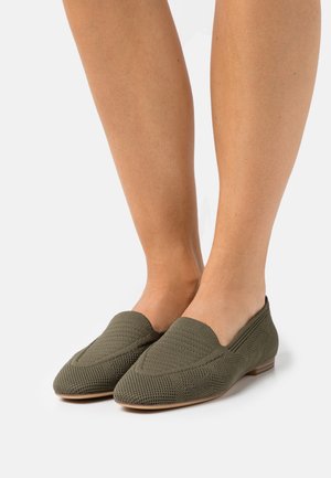 Chaussures slip-on vertes tricotées avec un bout pointu et un petit talon. Tissu texturé avec un motif, design flexible pour le confort.