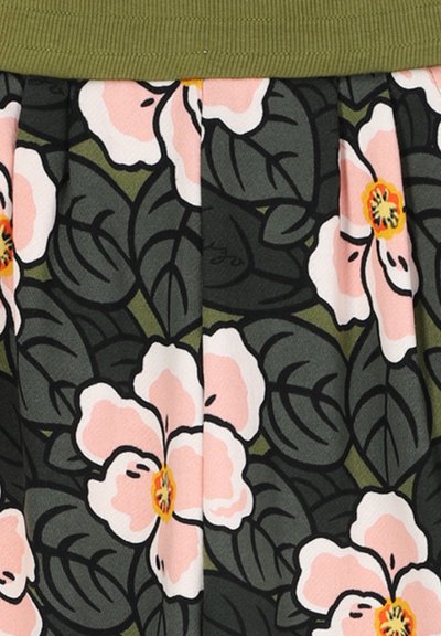 Donkergroene stof met grote lichtroze bloemen en donker omlijnde bladeren, verzameld onder een olijfgroen tailleband.