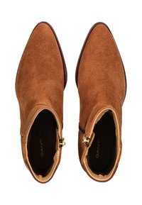 Braune Wildleder-Stiefeletten mit spitzer Zehenpartie, goldenem Reißverschluss an der Seite und glattem Innenfutter.
